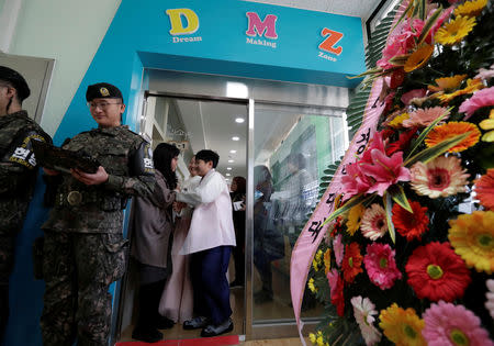 Graduates of elementary school talk with their teacher as they wait to attend at a graduation ceremony at Taesungdong freedom village inside the demilitarized zone between North and South Korea, near the border village of Panmunjom in Paju, South Korea, Friday, Jan. 11, 2019. Lee Jin-man/Pool via REUTERS