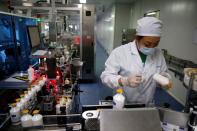 An employee works at a packaging line for chicken vaccine at Ringpu Biotech in Tianjin