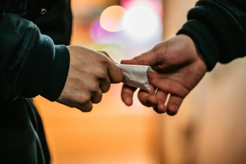 Two individuals exchanging a business card, symbolizing professional networking or transaction