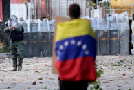 <p>A man with a Venezuelan flag stands in front of riot security forces while rallying against Venezuela’s President Nicolas Maduro’s government in Caracas, Venezuela, July 26, 2017. (Photo: Ueslei Marcelino/Reuters) </p>