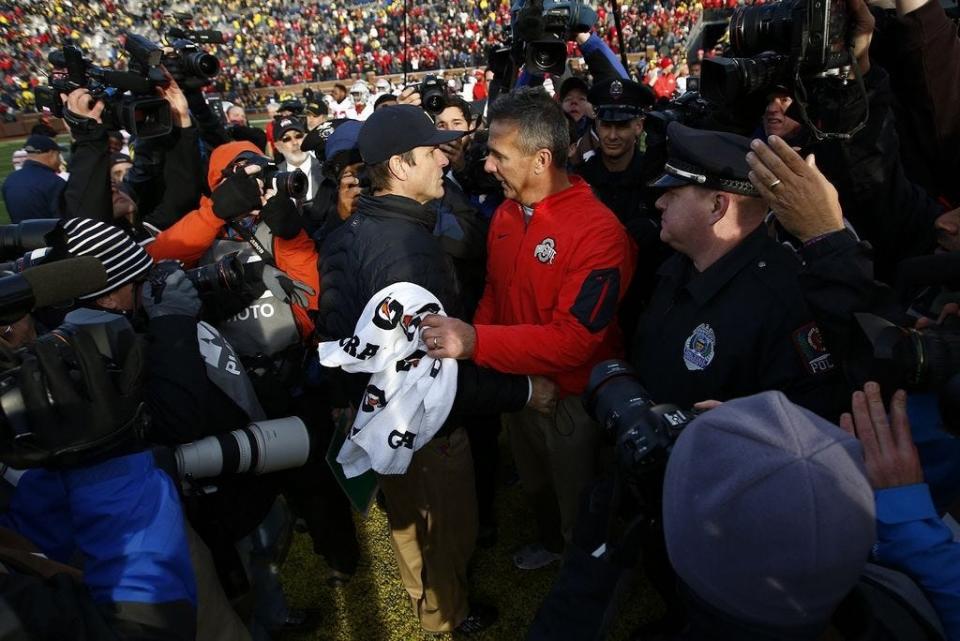 Michigan Wolverines head coach Jim Harbaugh and Ohio State Buckeyes head coach Urban Meyer shake hands after the college football game between the Michigan Wolverines and the Ohio State Buckeyes at Michigan Stadium in Ann Arbor, Saturday afternoon, November 28, 2015. The Ohio State Buckeyes defeated the Michigan Wolverines 42 - 13. (The Columbus Dispatch / Eamon Queeney)