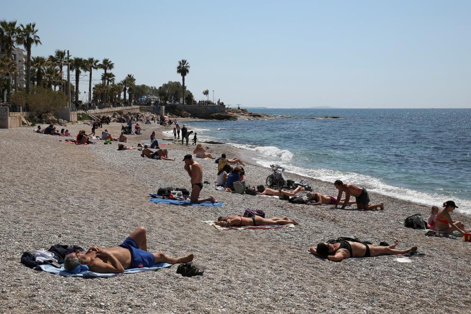 <p>People enjoying the beach in a suburb of Athens, Greece</p> (REUTERS)