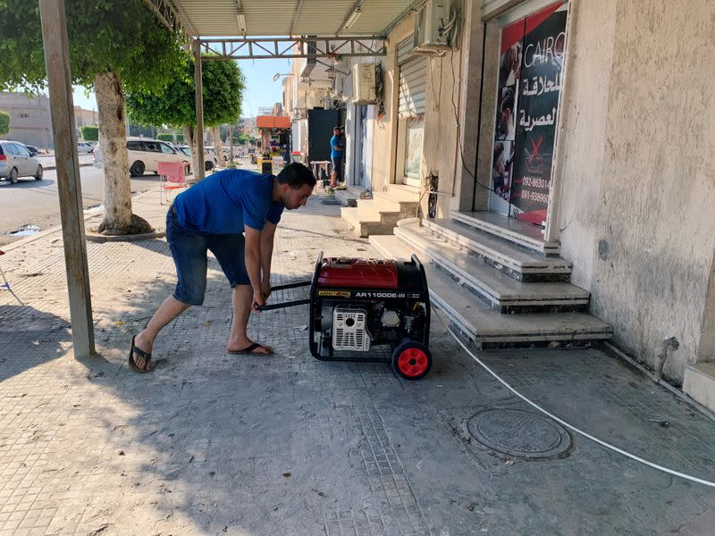 A barber prepares his generator at his shop during the long-lasting power blackouts, in Misrata