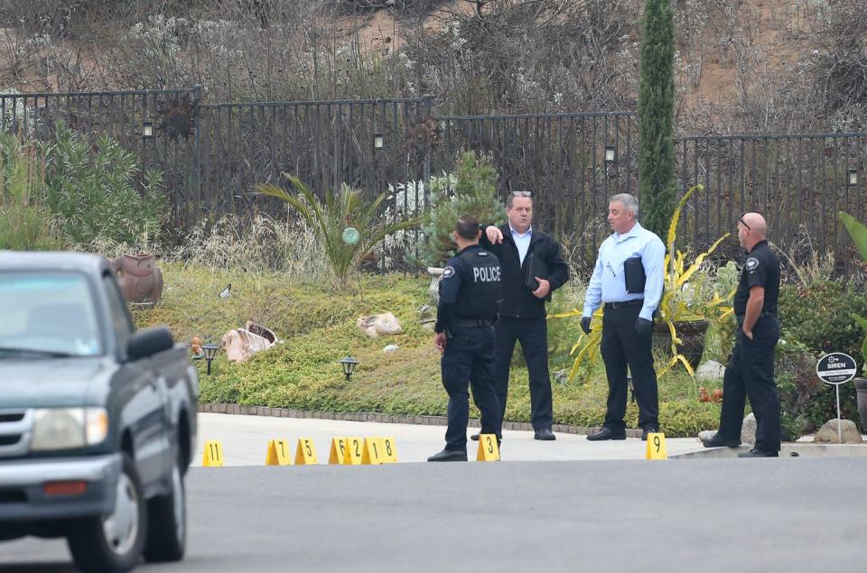 Police gathered outside a house where a man with a rifle was shot.