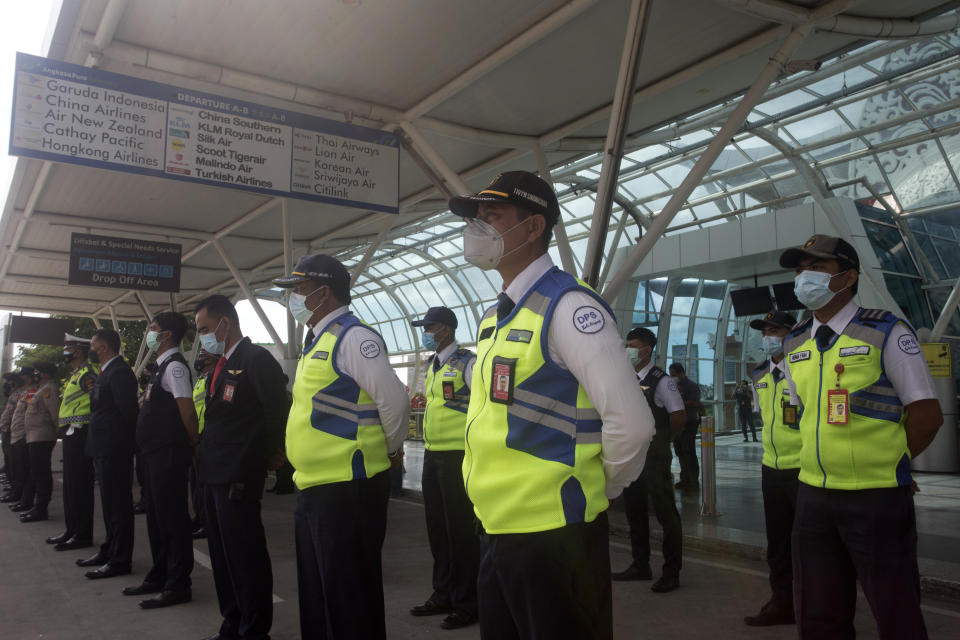 Airport security personnel line up during a briefing in preparation of the reopening of International Ngurah Rai Airport in Bali, Indonesia, Thursday, Oct. 14, 2021. The Indonesian resort island of Bali welcomed international travelers to its shops and white-sand beaches for the first time in more than a year Thursday - if they're vaccinated, test negative, hail from certain countries, quarantine and heed restrictions in public. (AP Photo/Firdia Lisnawati)