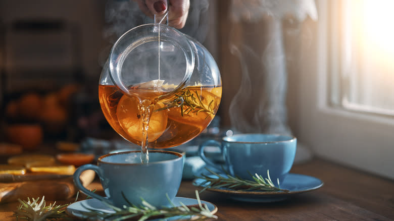 Teapot pouring orange fruit tea