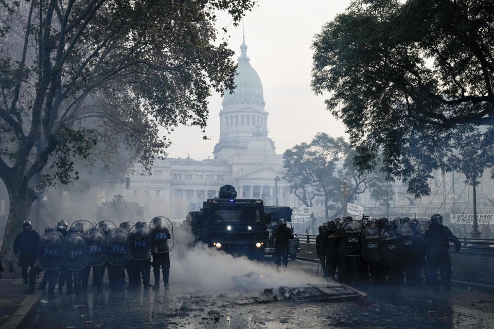 La policía despeja las calles tras un enfrentamiento con manifestantes contra el gobierno en las afueras del Congreso, donde senadores debaten reformas impulsadas por el presidente argentino Javier Milei, en Buenos Aires, Argentina, el miércoles 12 de junio de 2024. (AP Foto/Rodrigo Abd)