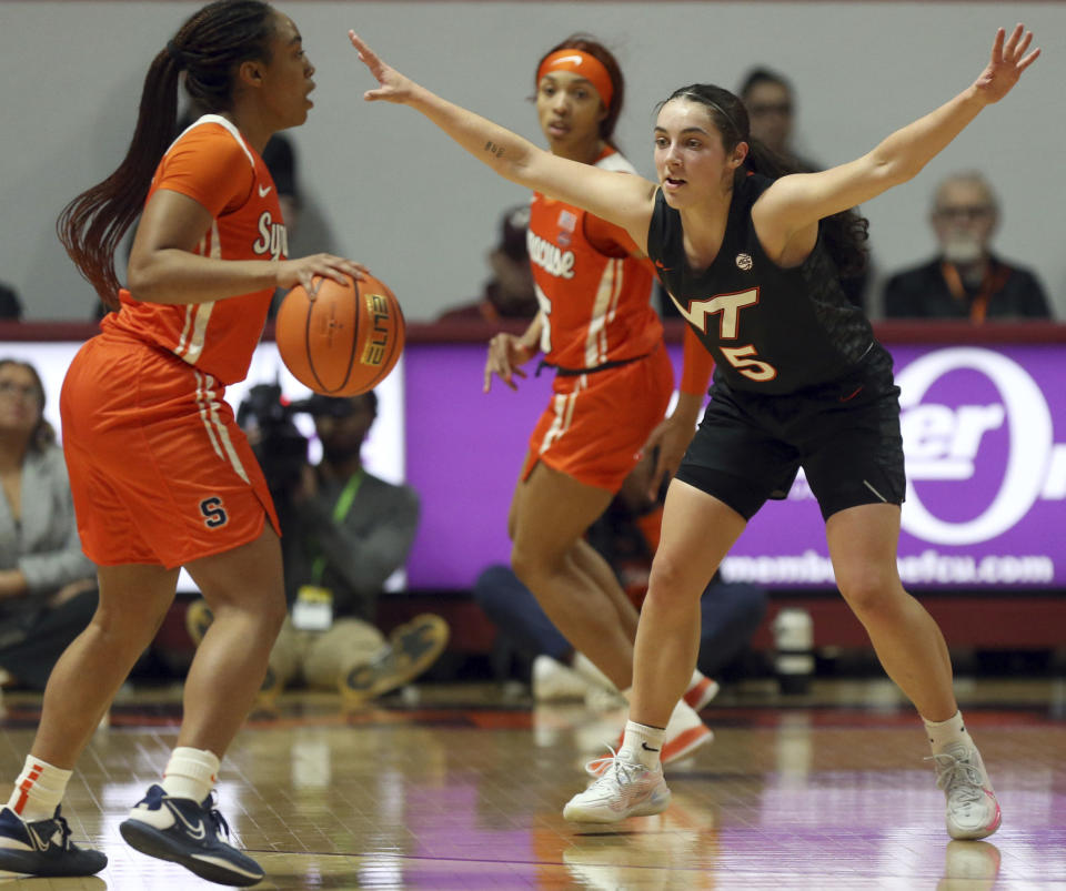 Syracuse's Kennedi Perkins, left, looks to pass while guarded by Virginia Tech's Georgia Amoore (5) during the first half of an NCAA college basketball game in Blacksburg, Va., Thursday, Feb. 2, 2023. (Matt Gentry/The Roanoke Times via AP)
