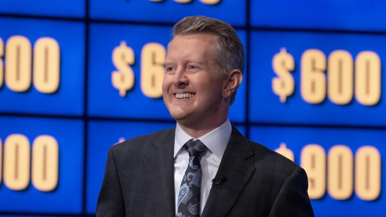  Ken Jennings smiling in front of game board on Celebrity Jeopardy! 