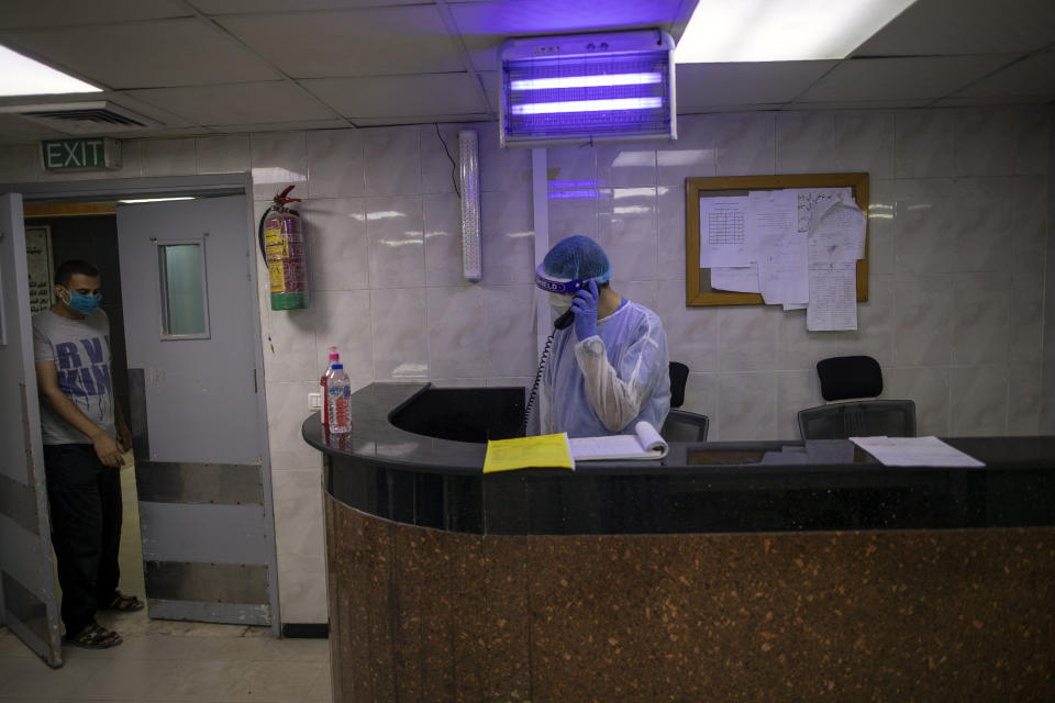 Palestinian doctors wear protective clothes as they work at the emergency room of the al-Quds Hospital in Gaza City, Monday, Sept. 7, 2020. Dozens of front-line health care workers have been infected, dealing a new blow to overburdened hospitals. (AP Photo/Khalil Hamra)