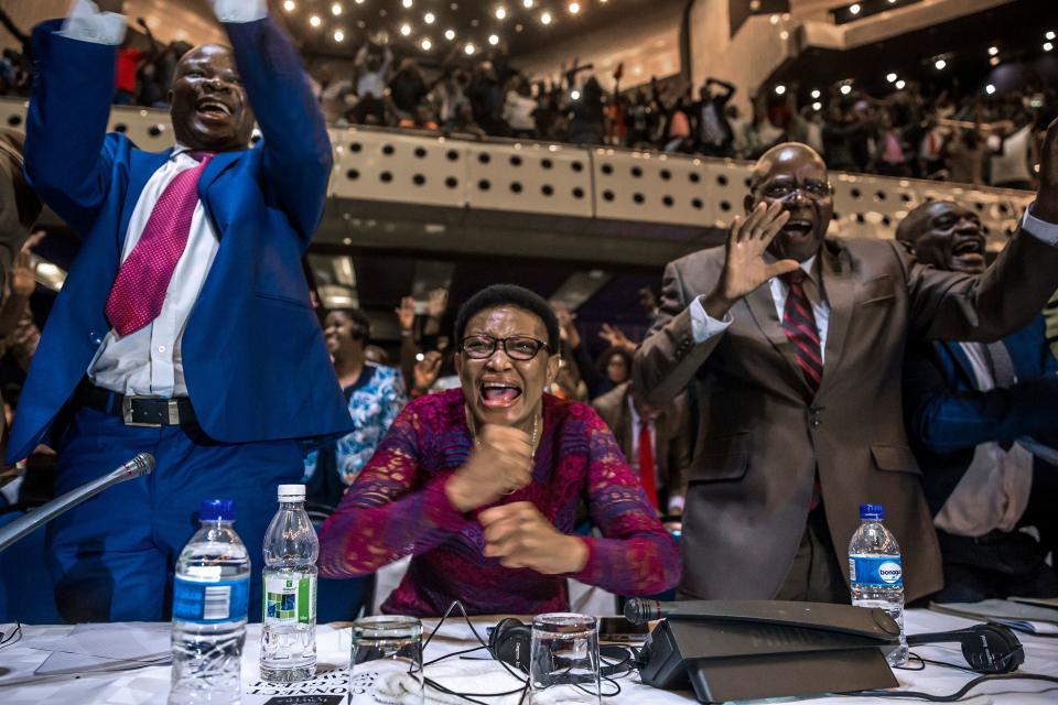 <p>Zimbabwe’s members of parliament celebrate after Mugabe’s resignation on Nov. 21, 2017 in Harare.<br> (Photo: Jekesai Njikizana/AFP/Getty Images) </p>