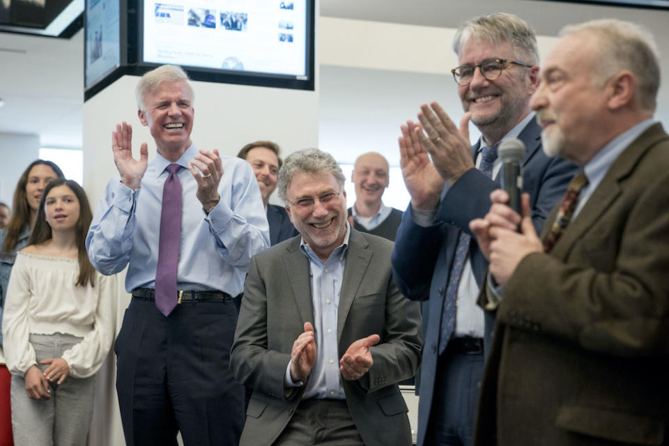 From left, Washington Post Publisher Fred Ryan, Executive Editor Marty Baron, and National Security Editor Peter Finn, applaud as investigative reporter Tom Hamburger speaks to the newsroom after The Washington Post wins two Pulitzer prizes, Monday, April 16, 2018, in Washington. 