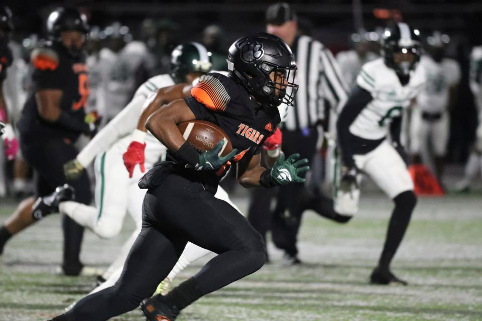 Belleville running back Jeremiah Beasley (1) runs the ball against Detroit Cass Tech during first-half action at Novi High School on Friday, Nov. 18, 2022.