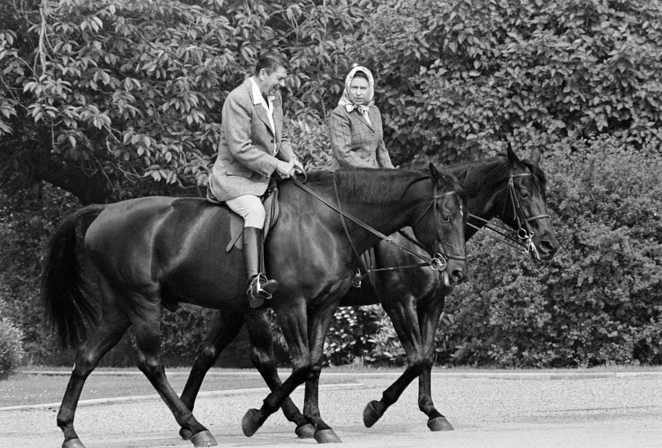 President Ronald Reagan and Queen Elizabeth II, in headscarf, out riding