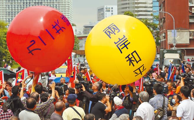 群眾在街頭遊行中滾動《九二共識》及《兩岸和平》大氣球。（王爵暐攝）