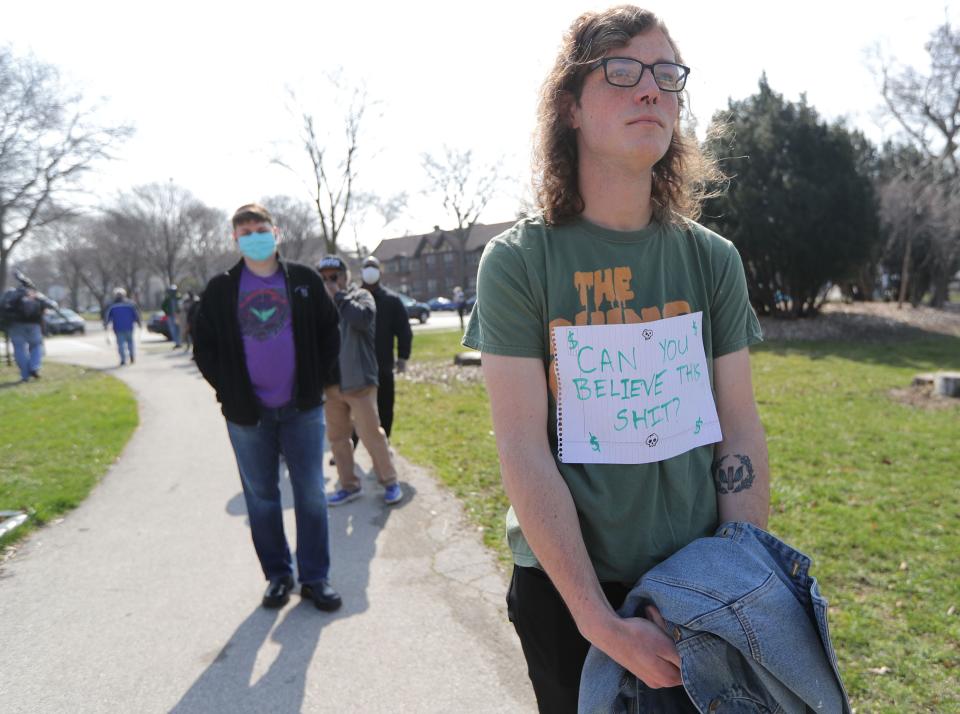 Ian Canovi, of Milwaukee, shows his views by a sign on attached to his shirt as he waits in line at Riverside High School, 1615 E. Locust St. in Milwaukee on Tuesday, April 7, 2020. The Wisconsin primary is moving forward despite the coronavirus epidemic after Gov. Tony Evers sought to shut down Tuesday's election in a historic move Monday that was swiftly rejected by the conservative majority of the Wisconsin Supreme Court.