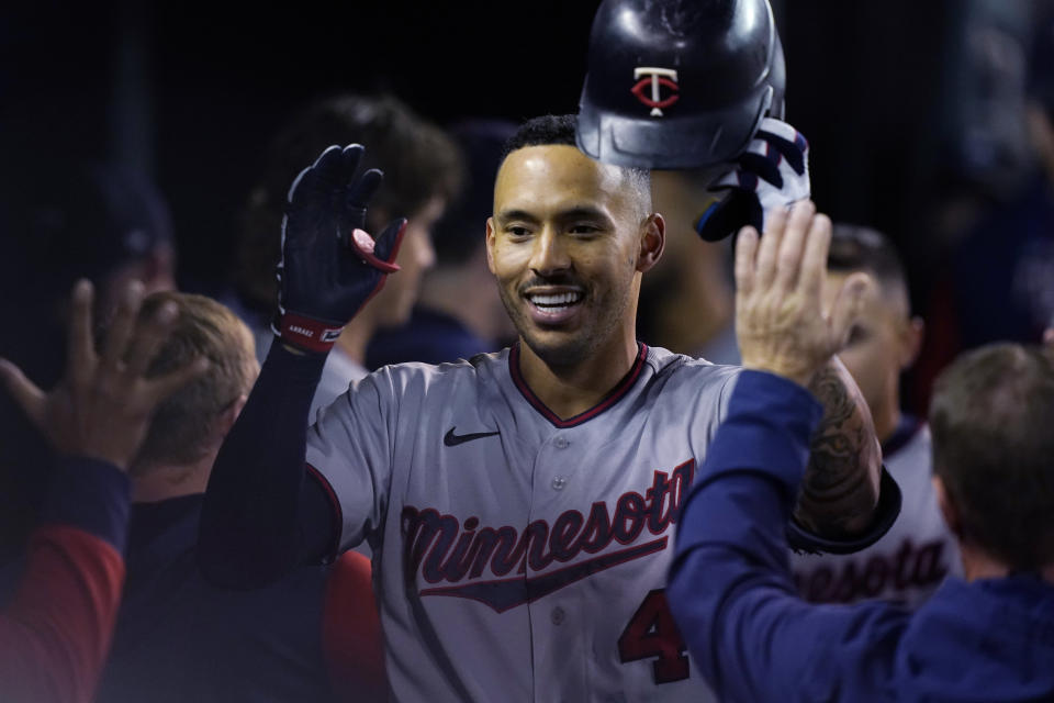 Minnesota Twins' Carlos Correa is greeted in the dugout after his two-run home run during the seventh inning of a baseball game against the Detroit Tigers, Friday, Sept. 30, 2022, in Detroit. (AP Photo/Carlos Osorio)