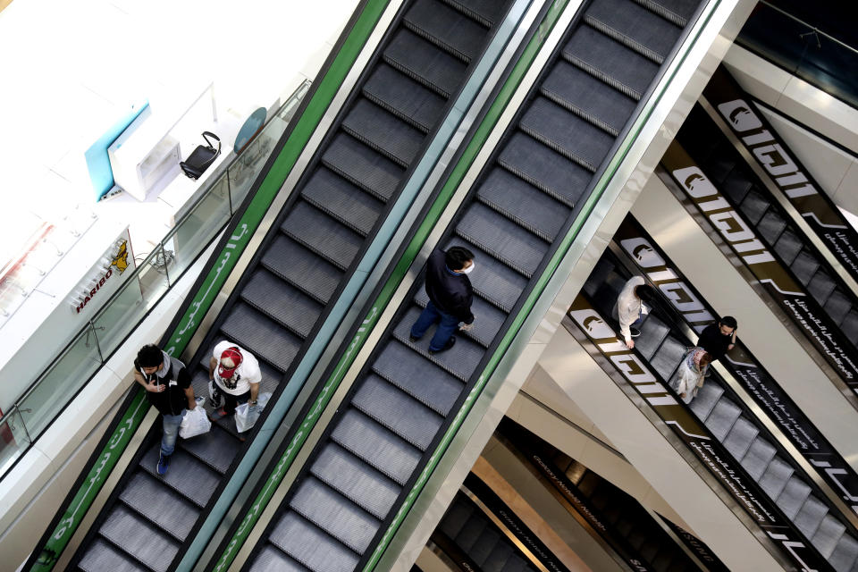 People ride escalators at the Kourosh Shopping Center in Tehran, Iran, Monday, April 20, 2020. Iran on Monday began opening intercity highways and major shopping centers to stimulate its sanctions-choked economy, gambling that it has brought under control its coronavirus outbreak — one of the worst in the world — even as some fear it could lead to a second wave of infections. (AP Photo/Vahid Salemi)