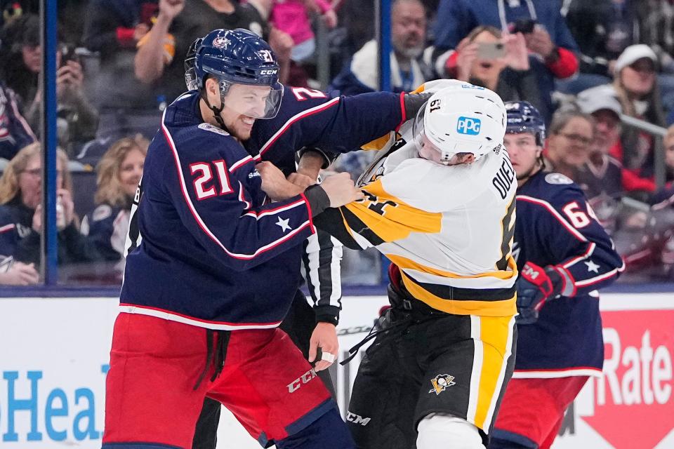 Sep 25, 2022; Columbus, Ohio, USA;  Columbus Blue Jackets center Josh Dunne (21) fights Pittsburgh Penguins defenseman Xavier Ouellet (61) during the third period of the preseason NHL hockey game at Nationwide Arena. Mandatory Credit: Adam Cairns-The Columbus Dispatch