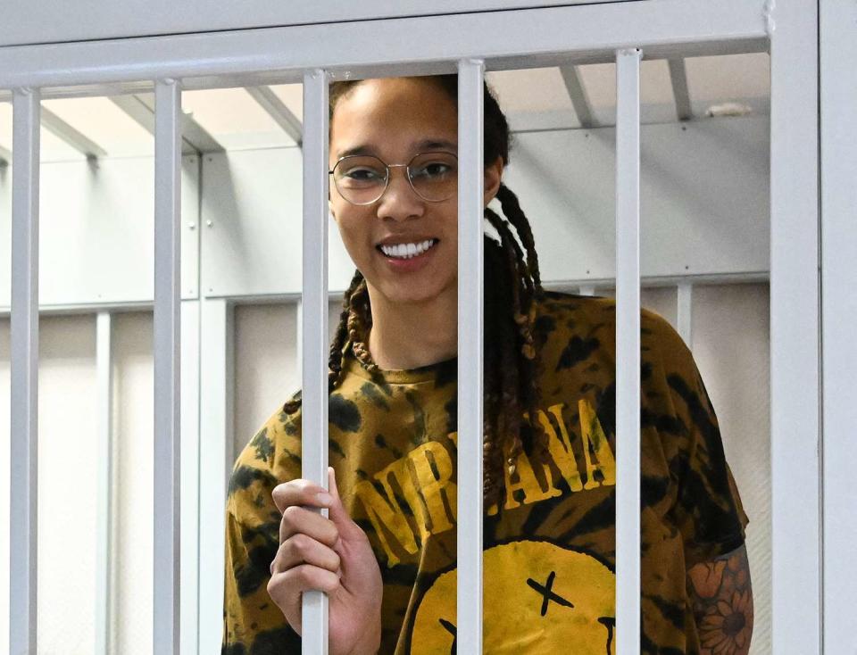 Brittney Griner smiles inside a defendants' cage during a hearing at the Khimki Court in the town of Khimki outside Moscow on July 15, 2022