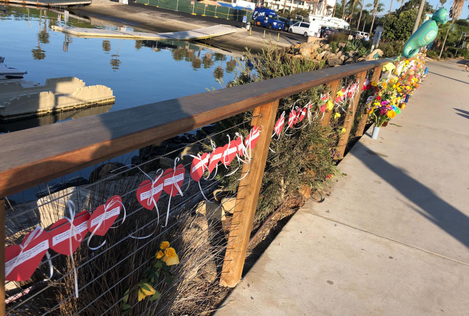 A row of hearts, each with the name of a victim, adorn a growing memorial to those who died aboard the dive boat Conception, seen early Friday morning, Sept. 6, 2019 at the harbor in Santa Barbara, Calif. The Sept. 2 fire took the lives of 34 people on the ship off Santa Cruz Island off the Southern California coast near Santa Barbara (AP Photo/Stefanie Dazio)