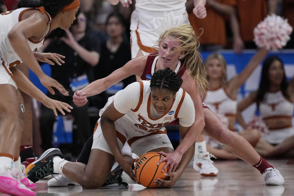 Texas forward Madison Booker, front, and Alabama guard Sarah Ashlee Barker, rear, scramble for a loose ball during the second half of a second-round college basketball game in the women’s NCAA Tournament in Austin, Texas, Sunday, March 24, 2024. (AP Photo/Eric Gay)