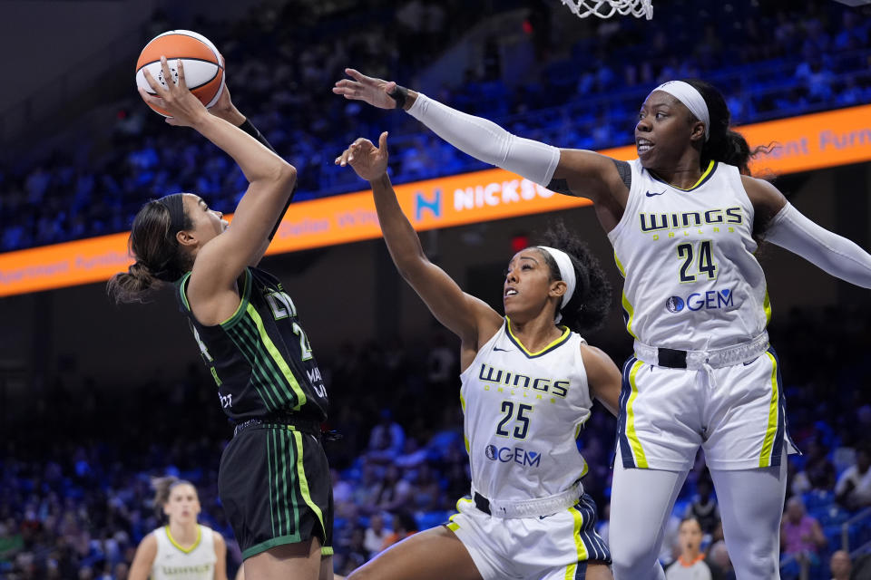 Minnesota Lynx forward Napheesa Collier, left, attempts to shoot as Dallas Wings' Monique Billings (25) and Arike Ogunbowale (24) defend in the second half of a WNBA basketball game in Arlington, Texas, Thursday, June 27, 2024. (AP Photo/Tony Gutierrez)