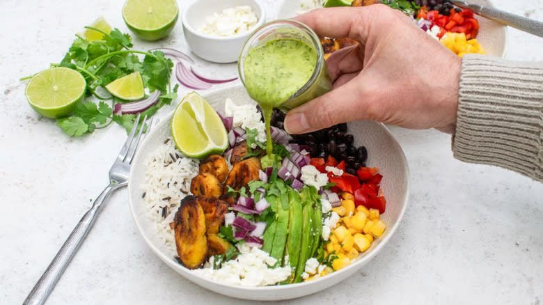 pouring dressing plantain and wild rice salad