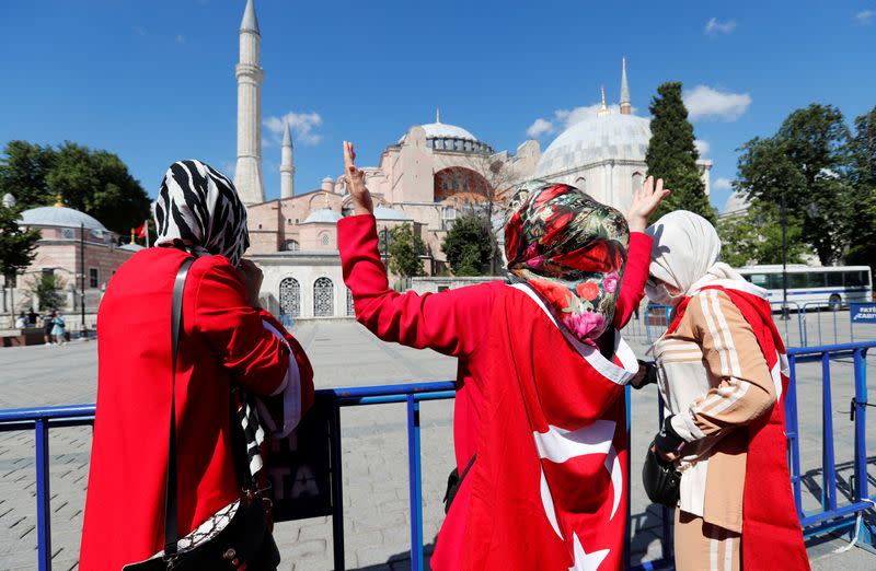 A woman gestures in front of the Hagia Sophia or Ayasofya, after a court decision that paves the way for it to be converted from a museum back into a mosque, in Istanbul