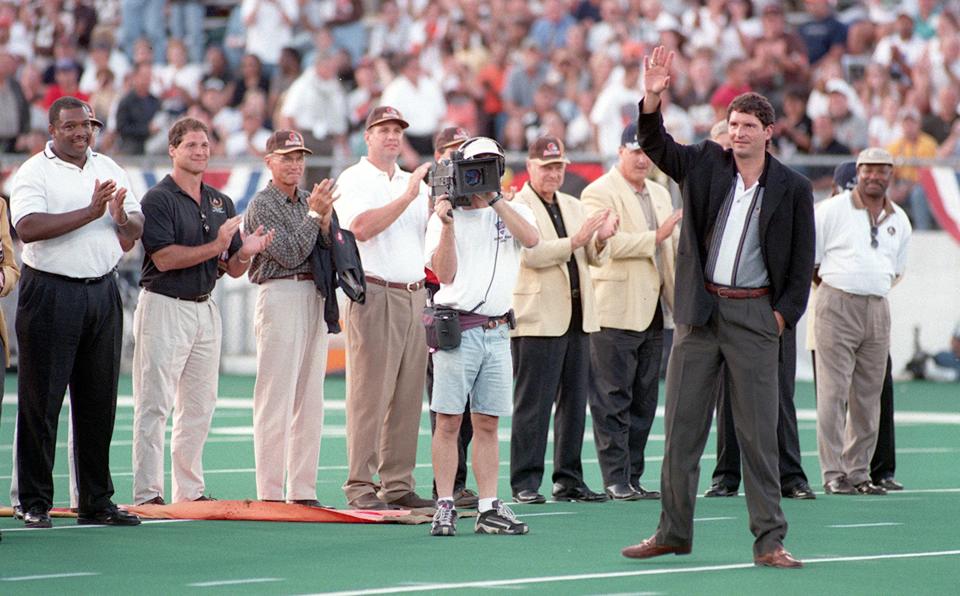 Bernie Kosar waves to fans before the Cleveland Browns defeated the Dallas Cowboys 20-17 in the Pro Football Hall of Fame Game on Aug. 9, 1999.