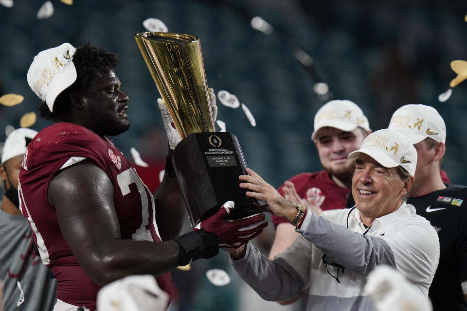 Alabama head coach Nick Saban and offensive lineman Alex Leatherwood hold the trophy after their win against Ohio State in the College Football Playoff title game. (AP Photo/Chris O'Meara)