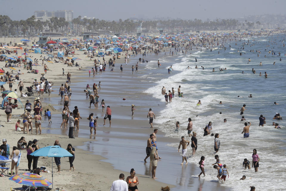 Visitors crowd the beach Sunday, July 12, 2020, in Santa Monica, Calif., amid the coronavirus pandemic. A heat wave has brought crowds to California's beaches as the state grappled with a spike in coronavirus infections and hospitalizations. (AP Photo/Marcio Jose Sanchez)