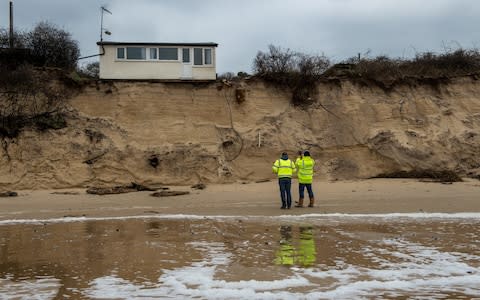 Building control surveyors on Hemsby beach in front of houses that have been evacuated - Credit: Chris J Ratcliffe /Getty