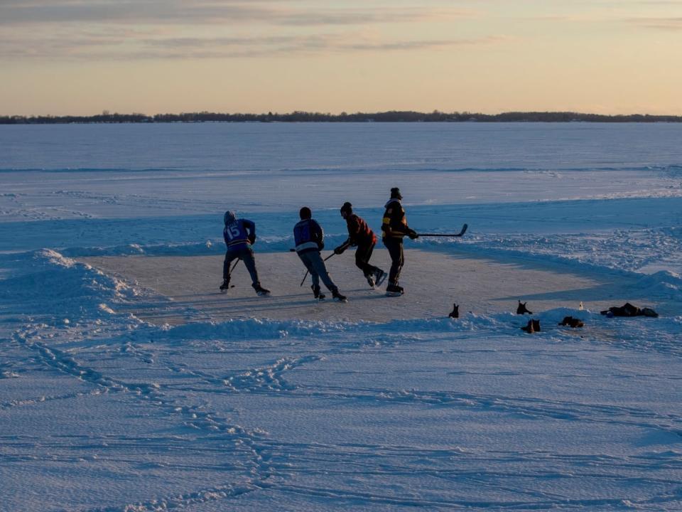 People play ice hockey on frozen Lake Ontario during sunset in Kingston, Ont., on Jan. 26, 2022. (Lars Hagberg/The Canadian Press - image credit)