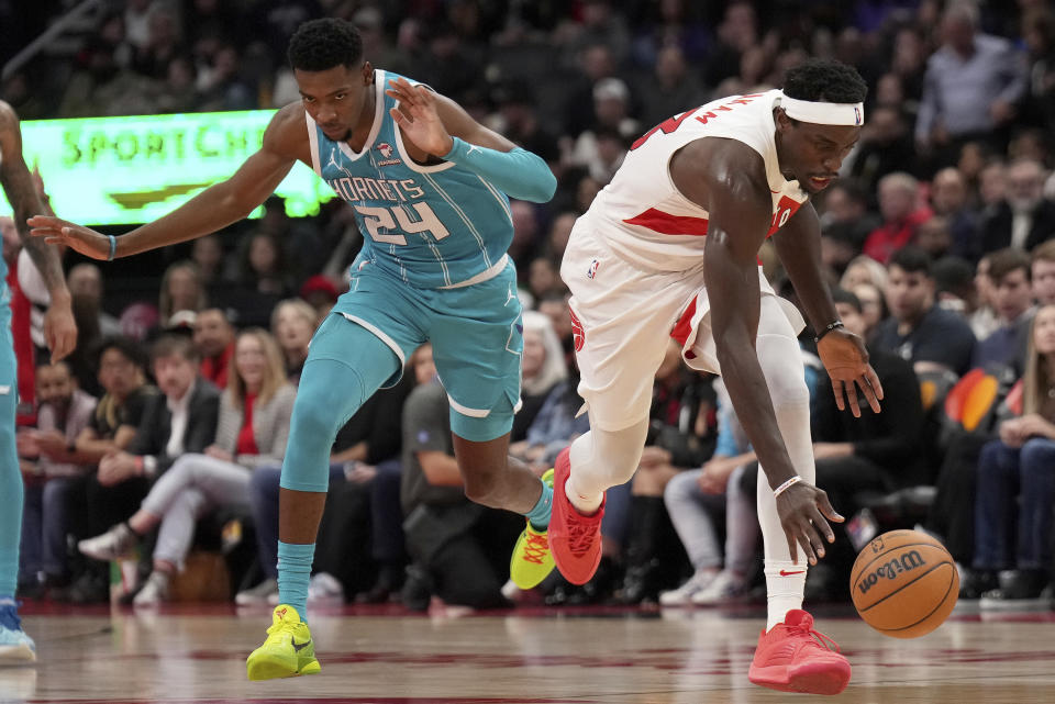 Toronto Raptors forward Pascal Siakam (43) chases a loose ball under pressure from Charlotte Hornets forward Brandon Miller (24) during the second half of an NBA basketball game in Toronto, Monday, Dec. 18, 2023. (Nathan Denette/The Canadian Press via AP)