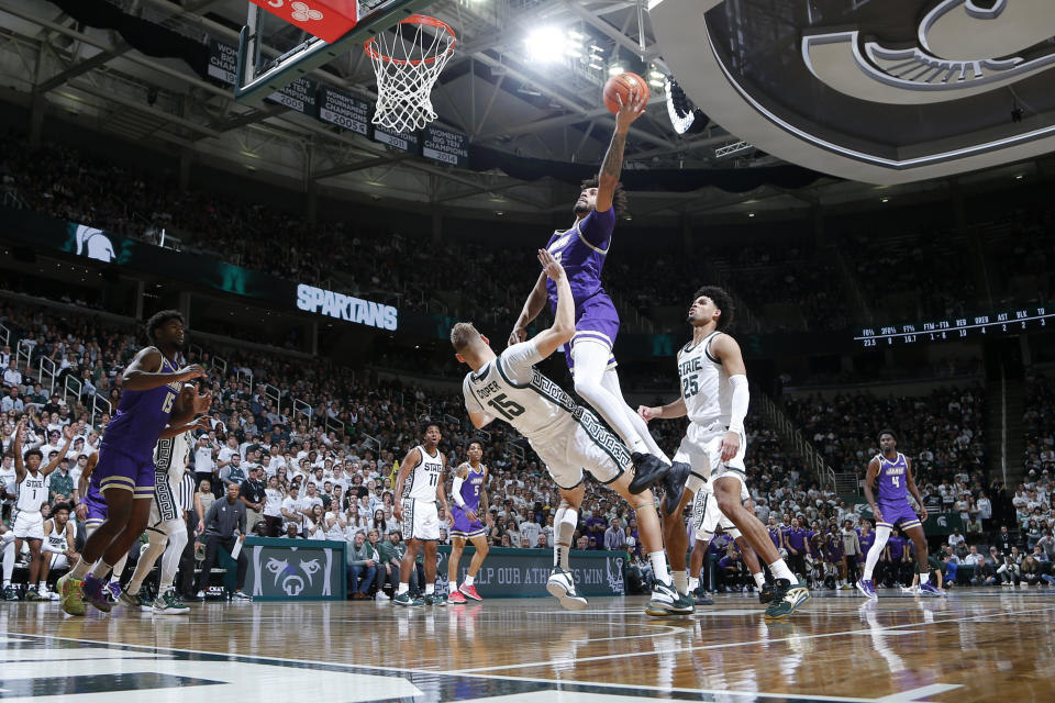 James Madison's Julien Wooden, top, goes up for a shot against Michigan State's Carson Cooper (15) during the first half of an NCAA college basketball game, Monday, Nov. 6, 2023, in East Lansing, Mich. Wooden was called for a charge on the play. (AP Photo/Al Goldis)