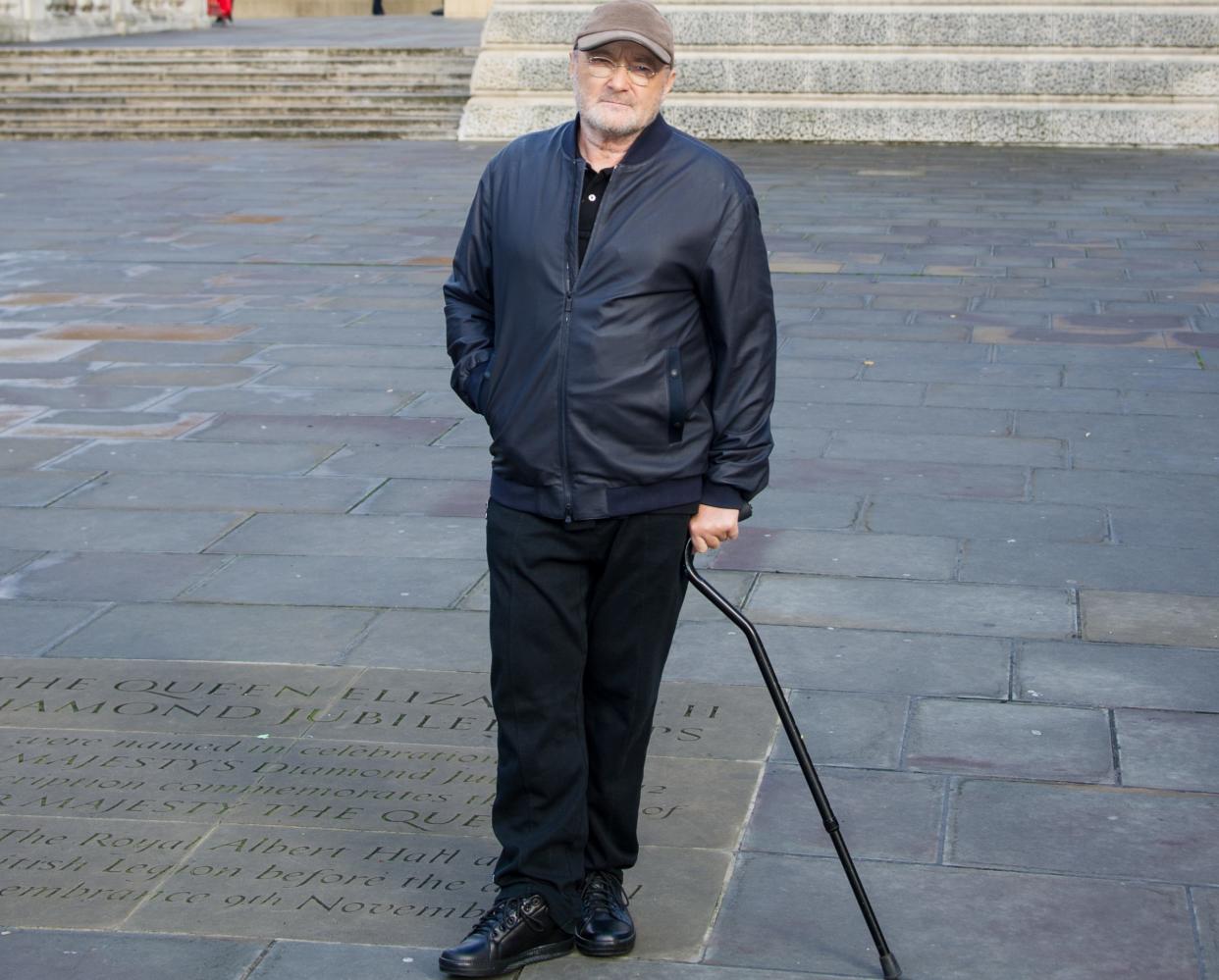 Phil Collins has walked with a stick for several years due to back pain (Credit: PA)