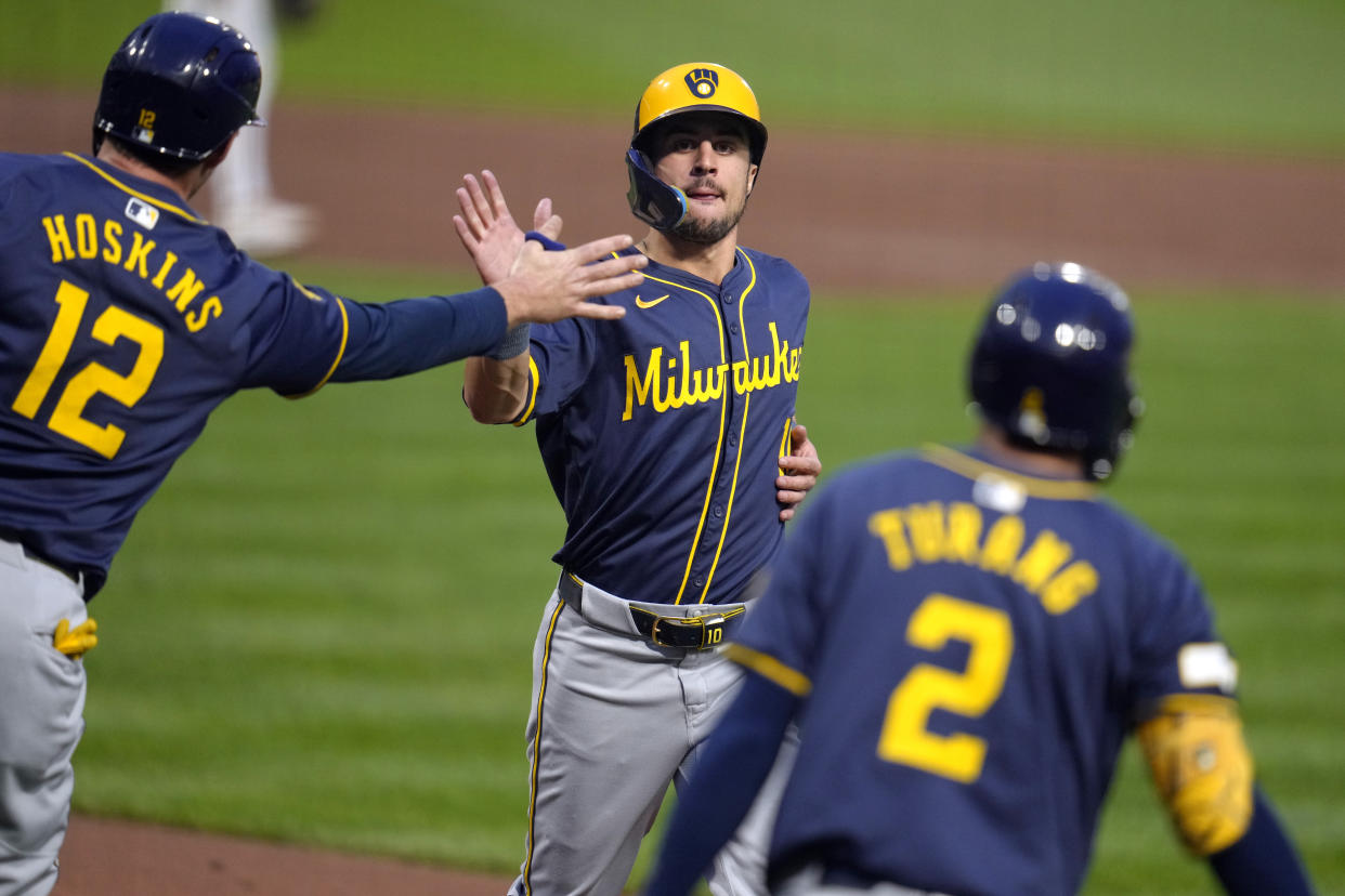 Milwaukee Brewers' Sal Frelick, center, is greeted by Rhys Hoskins (12) after both scored on a single by Joey Ortiz off Pittsburgh Pirates starting pitcher Bailey Falter during the second inning of a baseball game in Pittsburgh, Tuesday, Sept. 24, 2024. (AP Photo/Gene J. Puskar)