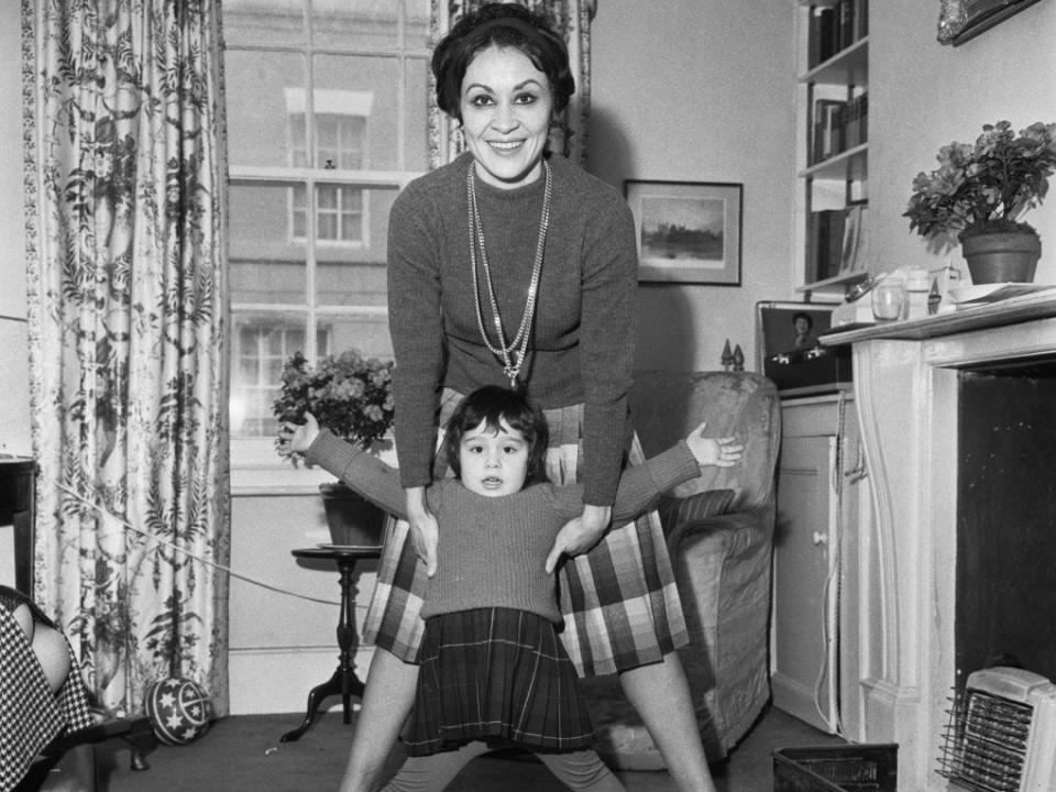 American actress and singer Chita Rivera, wearing a turtleneck sweater and playing with her daughter, Lisa Mordente, in London, England, 6th February 1962.