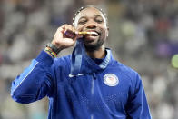 Gold medalist, Noah Lyles, of the United States, poses on the podium after the men's 100-meter final at the 2024 Summer Olympics, Monday, Aug. 5, 2024, in Saint-Denis, France. (AP Photo/Matthias Schrader)