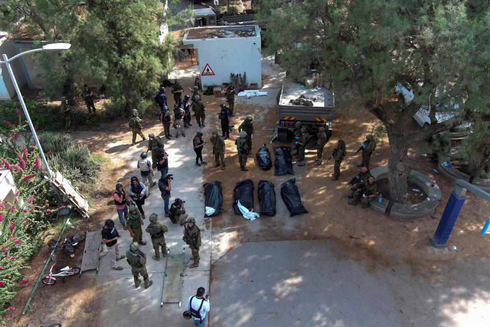 An aerial view shows covered bodies of victims of an attack by Hamas gunmen from the Gaza Strip, in Kibbutz Kfar Aza, in southern Israel, October 10, 2023. / Credit: Reuters/Ilan Rosenberg