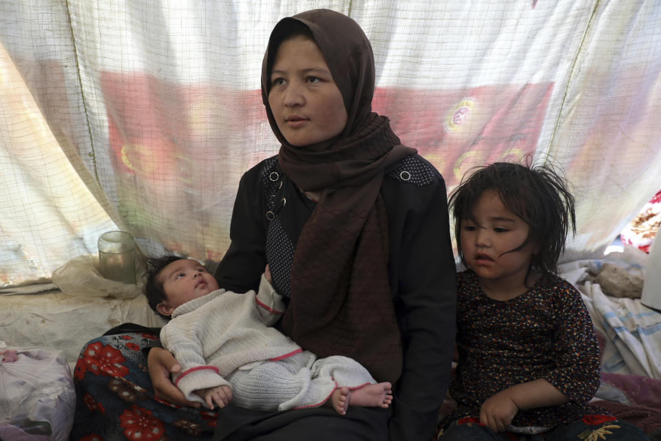 Fatima, an internally displaced Afghan woman who fled her home due to fighting between the Taliban and Afghan security personnel, speaks to The Associated press at a camp on the outskirts of Mazar-e-Sharif, northern Afghanistan, Thursday, July 8, 2021. Fatima, who cradled her sickly two-month old daughter Kobra, said she hadn't had much food or drink since arriving about one week ago and was unable to produce enough milk to feed her infant. (AP Photo/Rahmat Gul)