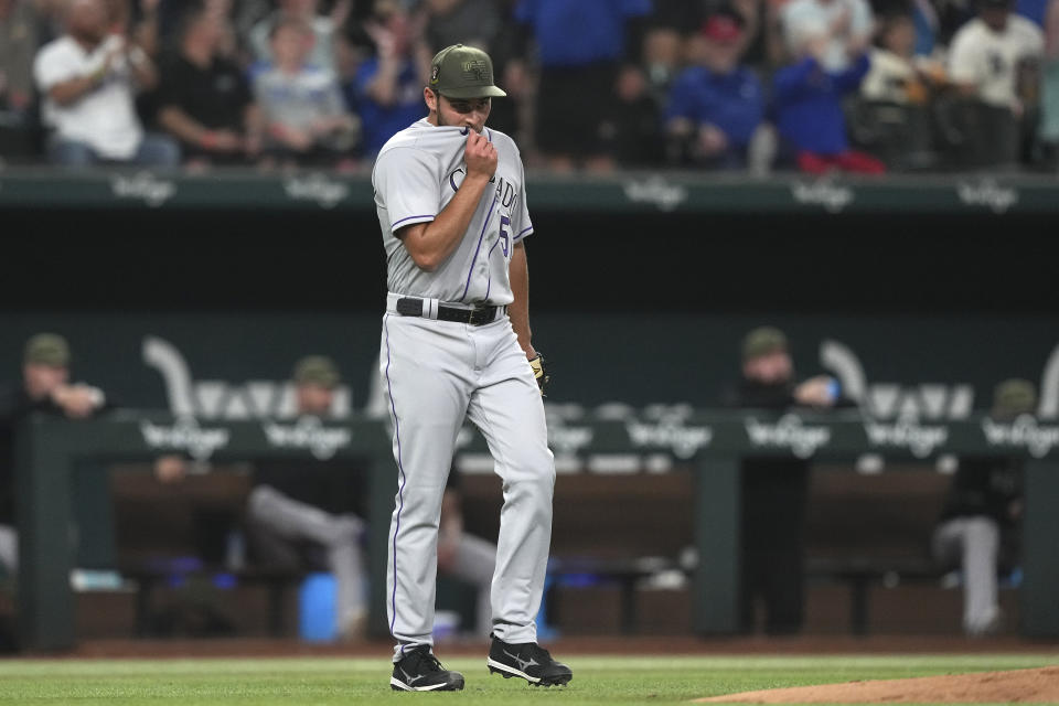 Colorado Rockies starting pitcher Karl Kauffmann wipes his face after giving up a two-un home run to Texas Rangers' Adolis Garcia during the fourth inning of a baseball game in Arlington, Texas, Friday, May 19, 2023. (AP Photo/LM Otero)