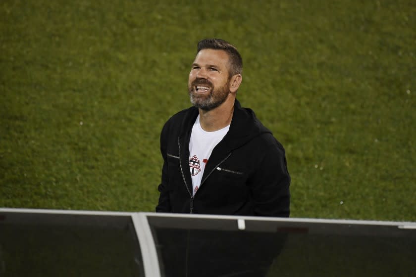 Toronto FC head coach Greg Vanney smiles during the first half of an MLS soccer match against Columbus Crew.