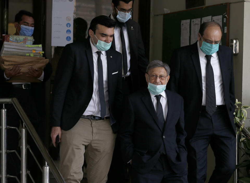 Farooq Naek, center, prosecutor from Sindh provincial government, leaves with his team from the Supreme Court after an appeal hearing of the Daniel Pearl case, in Islamabad, Pakistan, Wednesday, Oct. 7, 2020. Ahmed Omar Saeed Sheikh, who has been on death row over the 2002 killing of U.S. journalist Daniel Pearl, will remain in jail for another three months under a government order, a prosecutor told the country's top court Wednesday, as it took up appeals of Pearl’s family and government against acquittal of all accused of murder charges by another court. (AP Photo/Anjum Naveed)