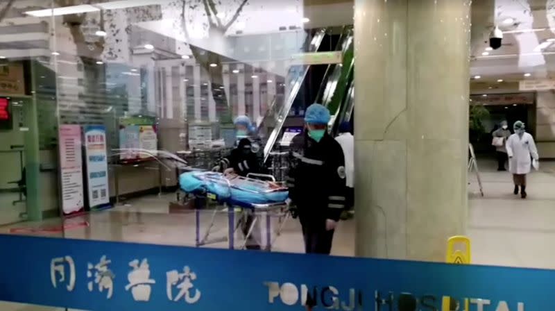 FILE PHOTO: People wearing masks work at a hospital in Wuhan