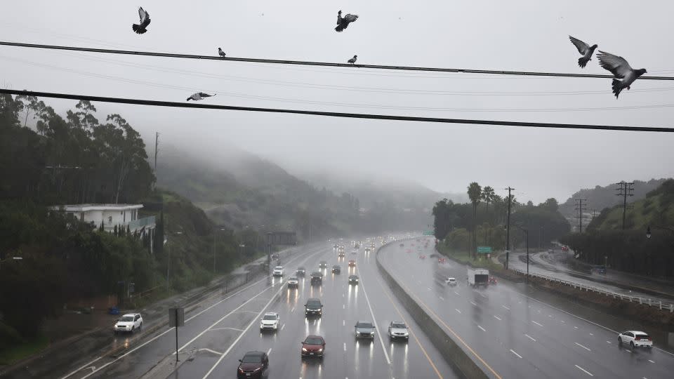 Vehicles drive through the rain on the 101 freeway on Monday in Los Angeles. - Mario Tama/Getty Images