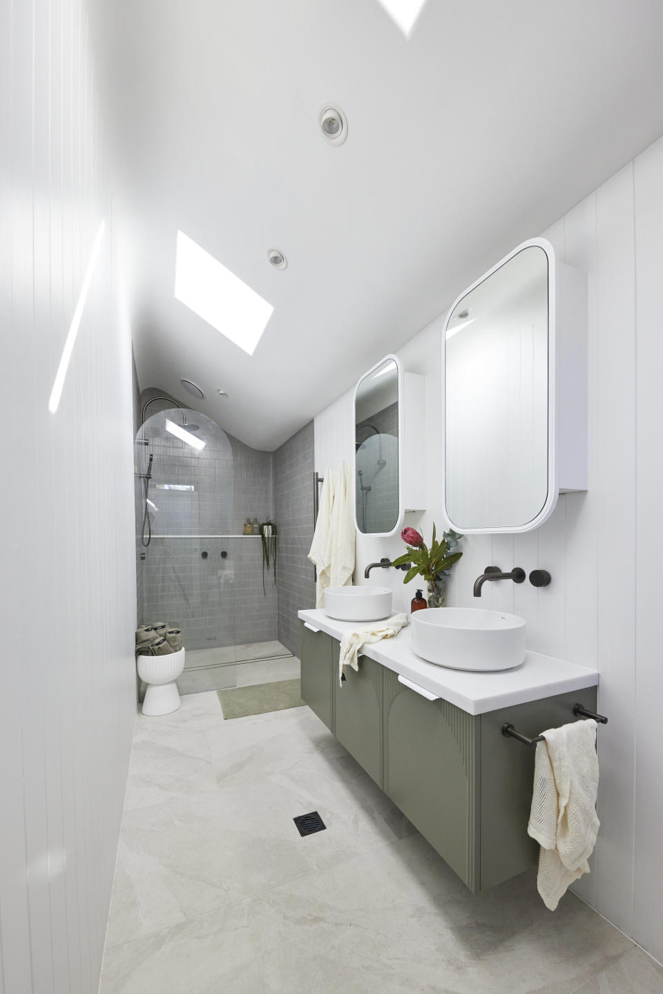The vanity and benches on the right, skylights and white walls. 
