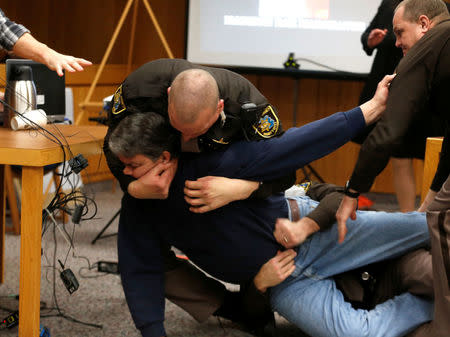 Eaton County Sheriffs restrain Randall Margraves after he lunged at Larry Nassar, a former team USA Gymnastics doctor, who pleaded guilty in November 2017 to sexual assault charges, during victim statements of his sentencing in the Eaton County Circuit Court in Charlotte, Michigan, U.S., February 2, 2018. REUTERS/Rebecca Cook