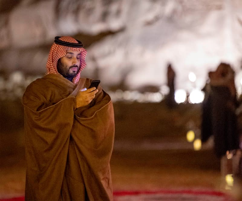 FILE PHOTO: Saudi Arabia's Crown Prince Mohammed bin Salman uses his phone during a meeting with Japan's Prime Minister Shinzo Abe in Riyadh